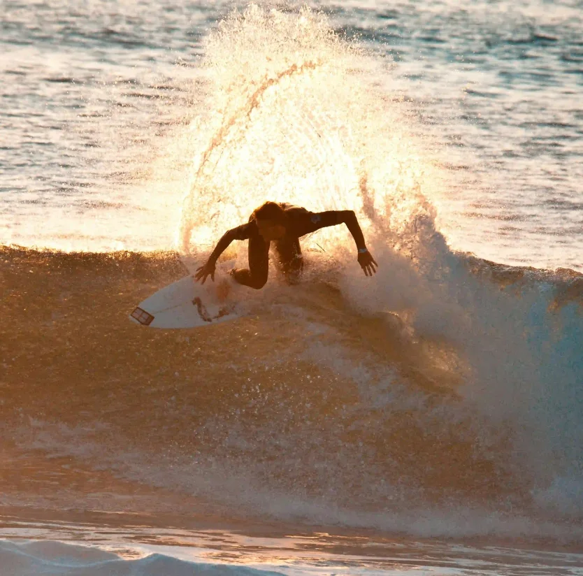Surfer performing a powerful turn on a golden sunset wave at Nicaragua Surf Camp in Popoyo, Tola.