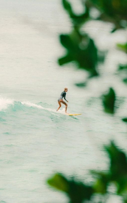 Surfer riding a clean turquoise wave near Magnific Rock in Popoyo, Nicaragua