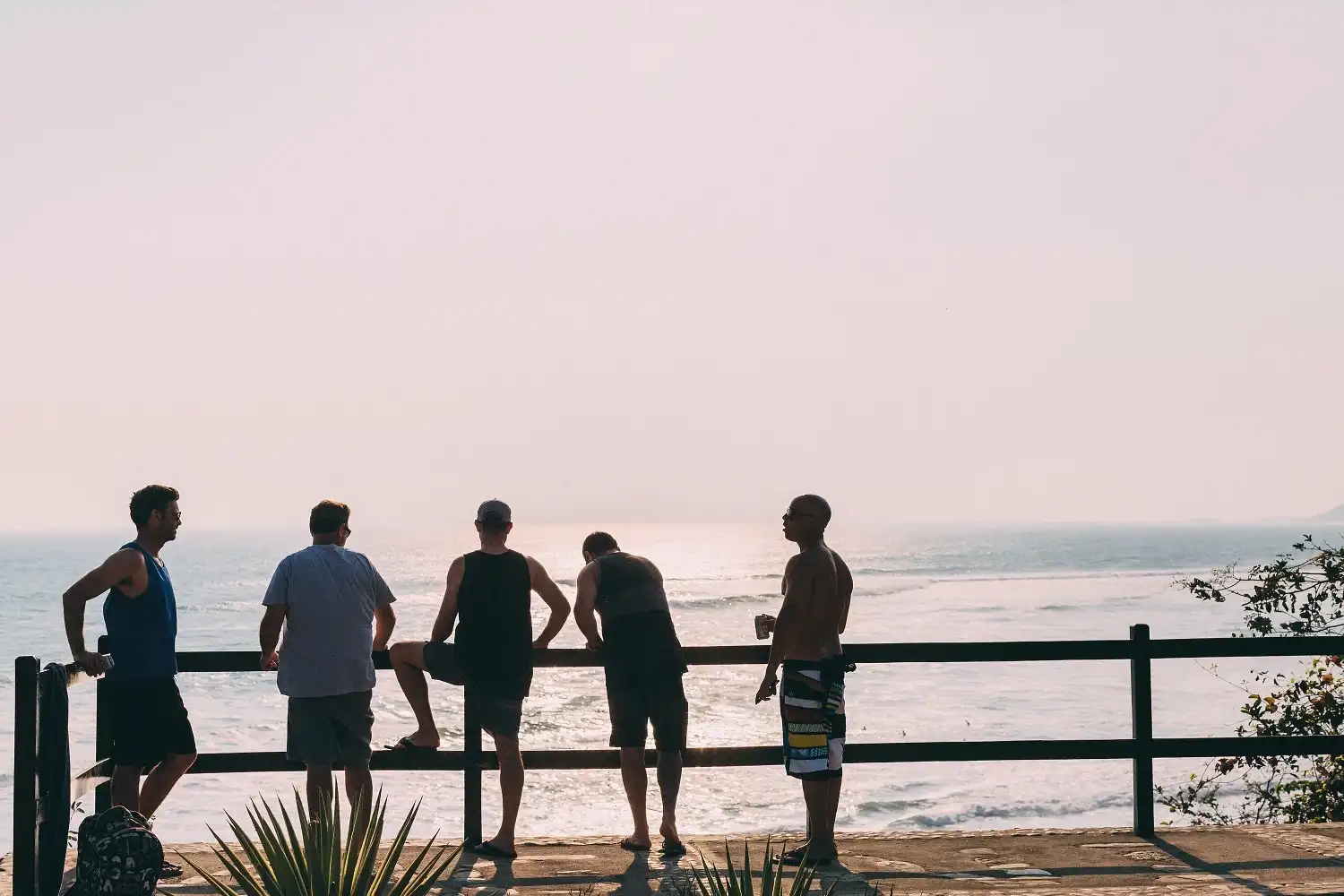 Group of surfers standing at an oceanview lookout near Magnific Rock in Popoyo, Nicaragua, watching incoming waves
