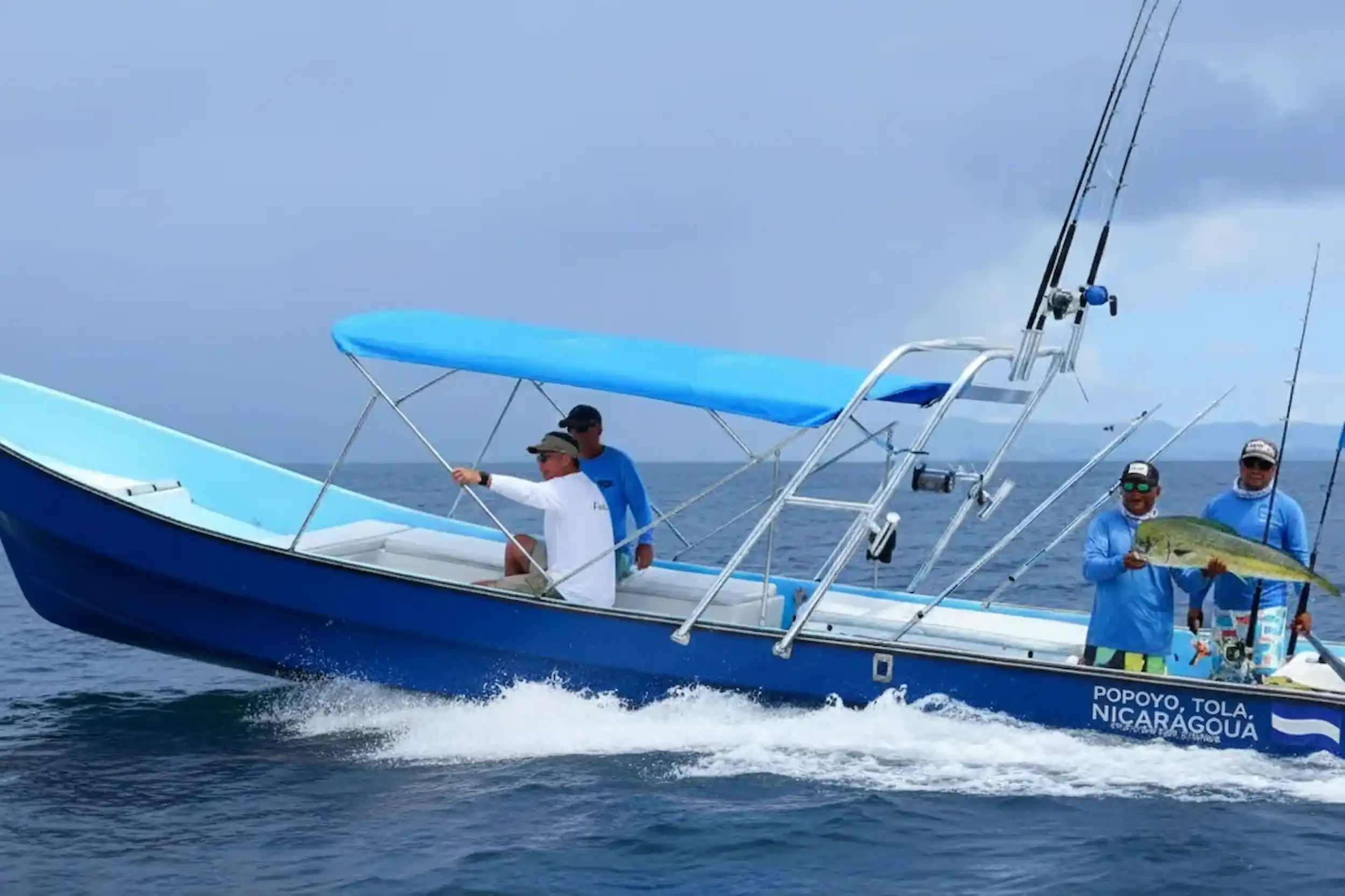 A group of anglers on a boat in Popoyo holding a large catch during an offshore fishing trip.