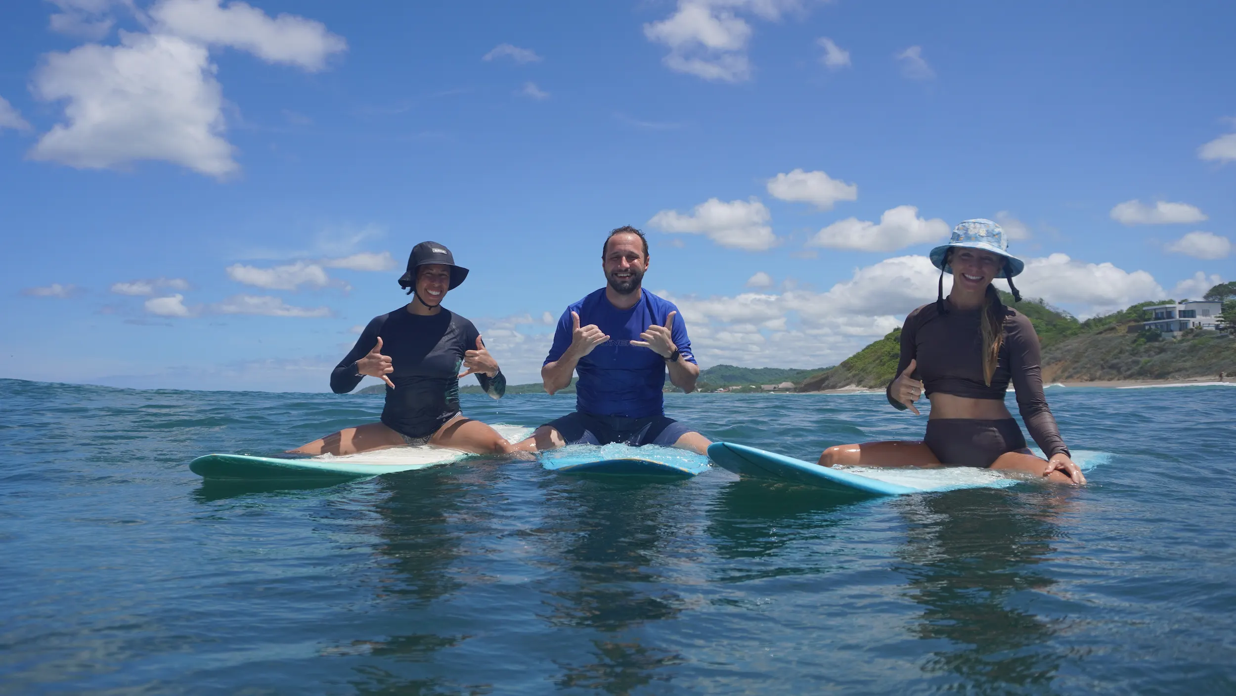 Group of surfers sitting on surfboards in the ocean in Nicaragua