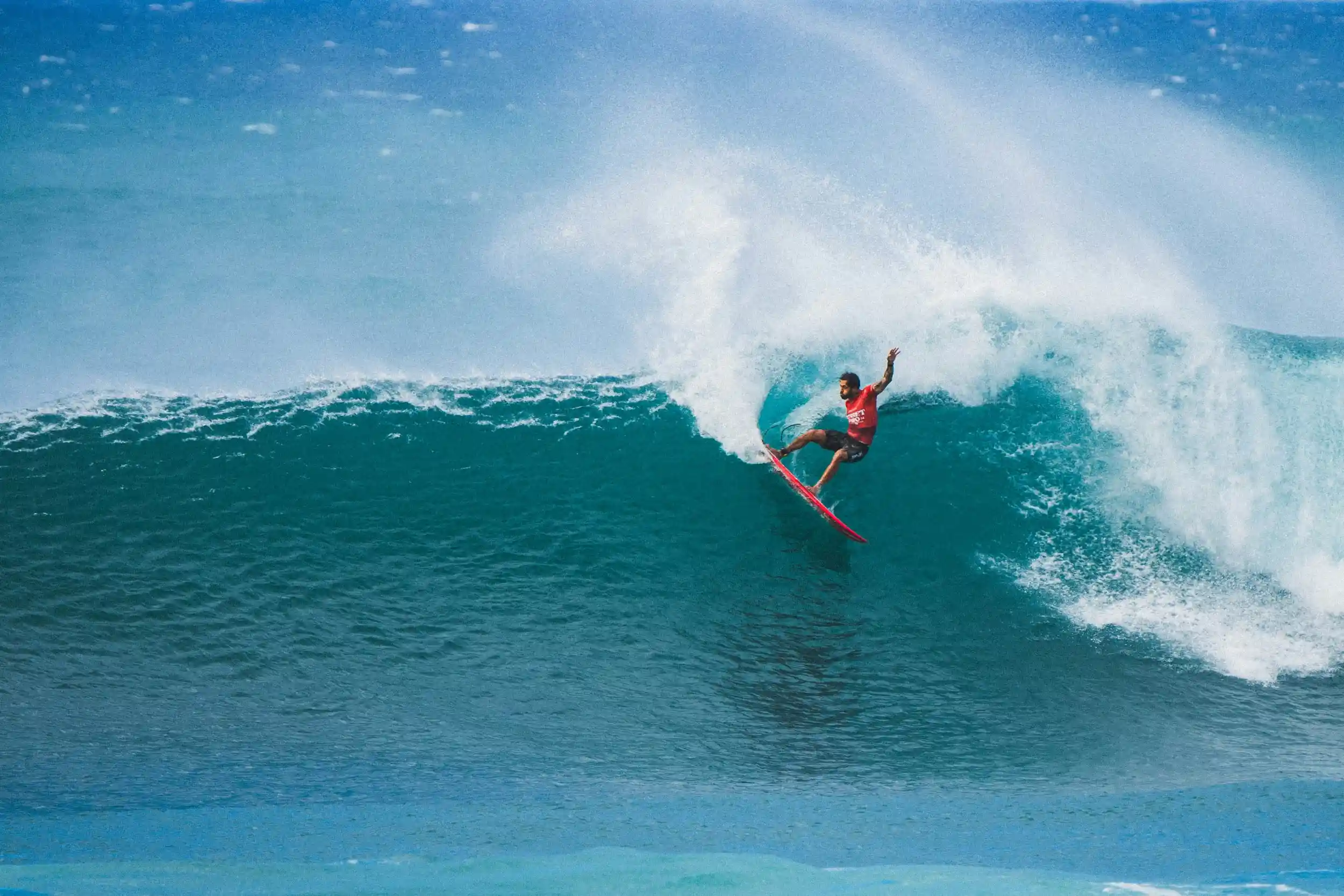 Advanced surfer carving a powerful open-face wave at Popoyo Outer Reef, throwing spray on a strong, fast-moving swell