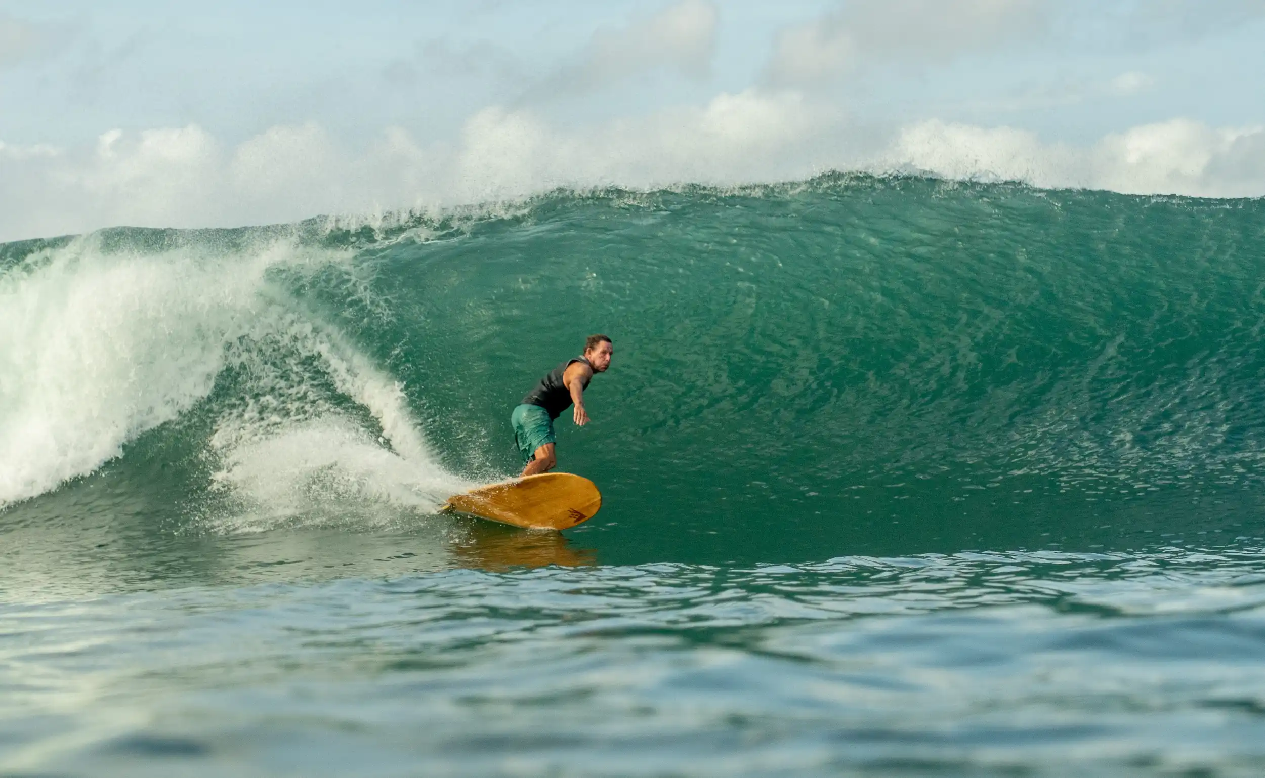 Surfer riding a clean, powerful green wave at Popoyo Reef with smooth face and strong tropical swell.