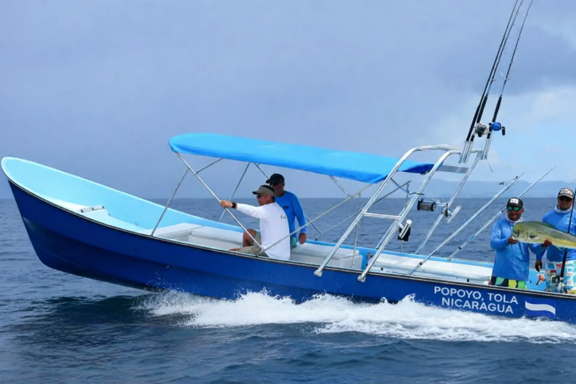 A group of anglers on a boat in Popoyo holding a large catch during an offshore fishing trip.