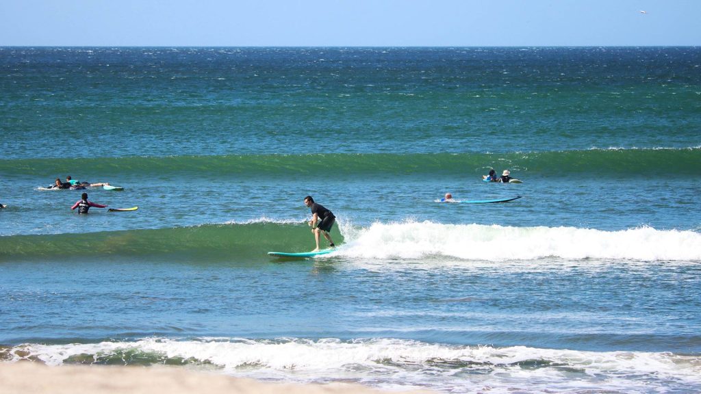 surf coach observing beginner surfer in uncrowded lineup at Nicaragua Surf Camp Popoyo
