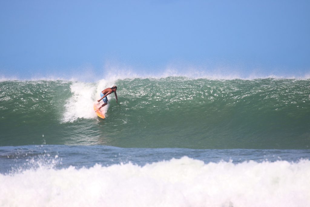 surfer riding a clean offshore wave at a beach break on the Pacific coast of Nicaragua near Popoyo