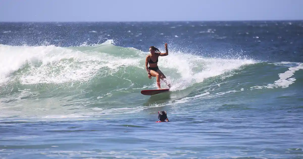surf instructor coaching a beginner on pop-up technique on a beach in Nicaragua